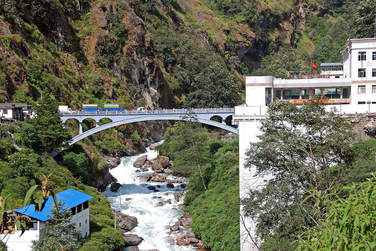 09 Friendship Bridge Between Kodari Nepal And Zhangmu Tibet After Crossing The Friendship Bridge From Kodari After passing through China Customs and Immigration, I walk up the road to our awaiting Landcruiser. I look back to see the thundering Bhote Kosi (�River From Tibet�) flowing under the Friendship Bridge.